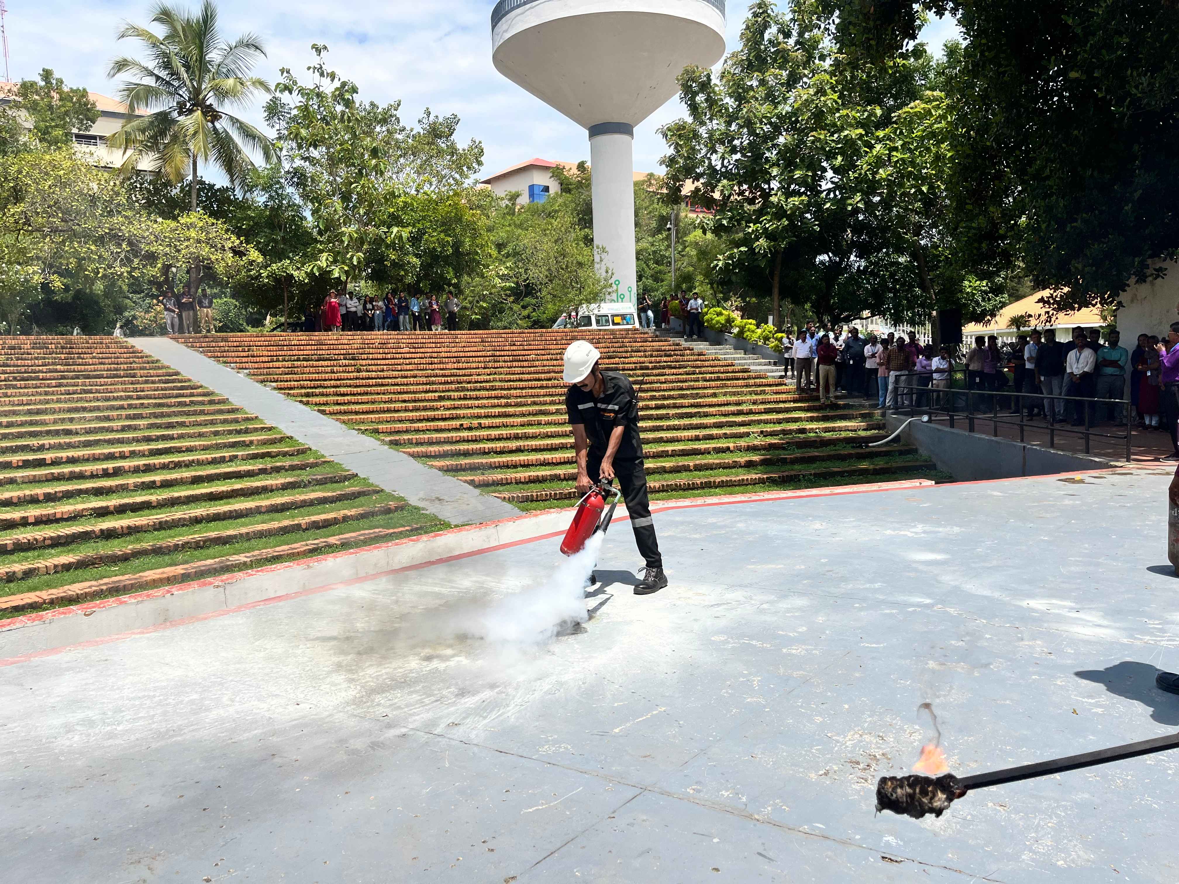 A fire and safety team member demonstrating how to extinguish fire.